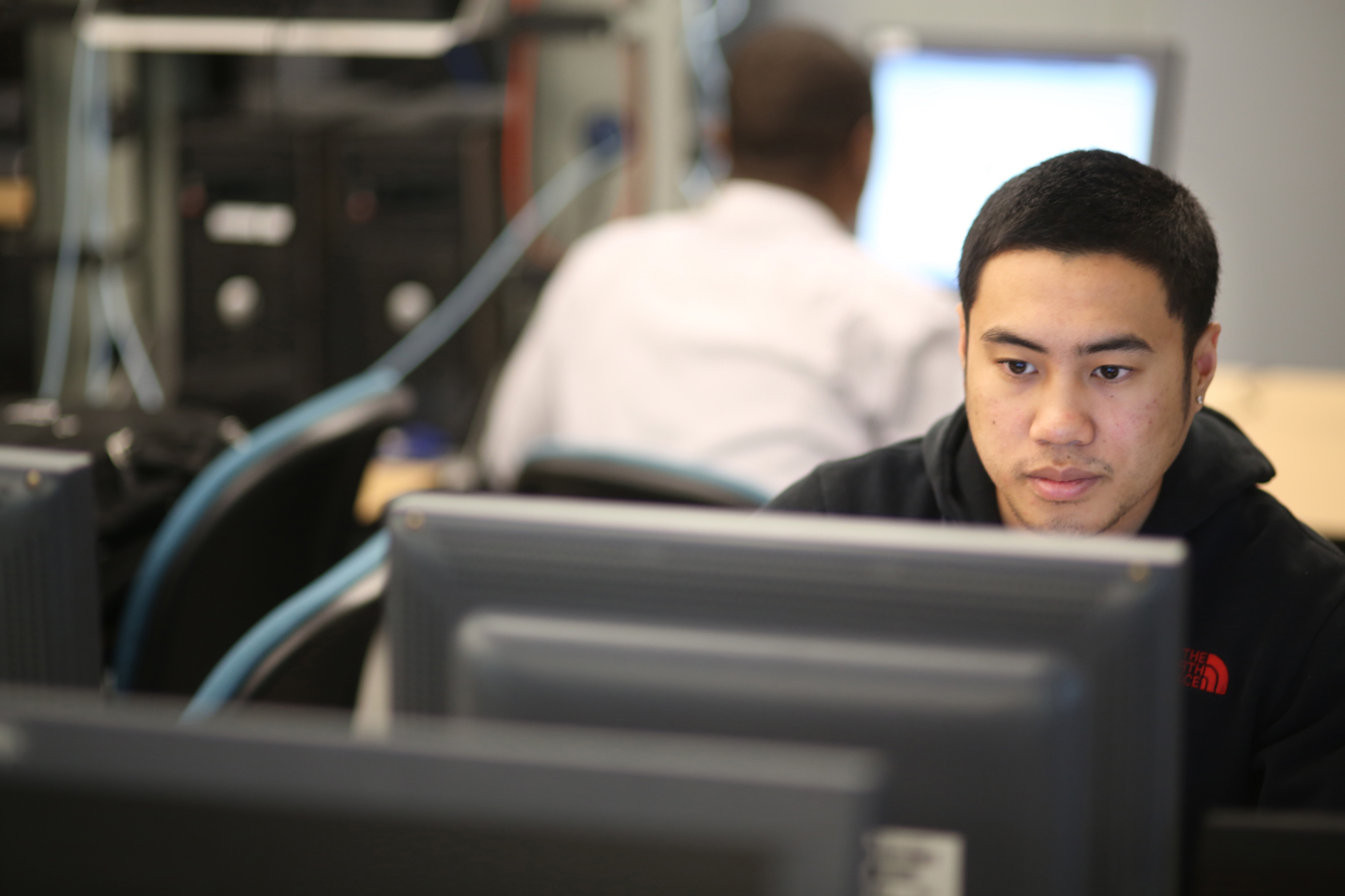 Image of a student facing a computer monitor studying.